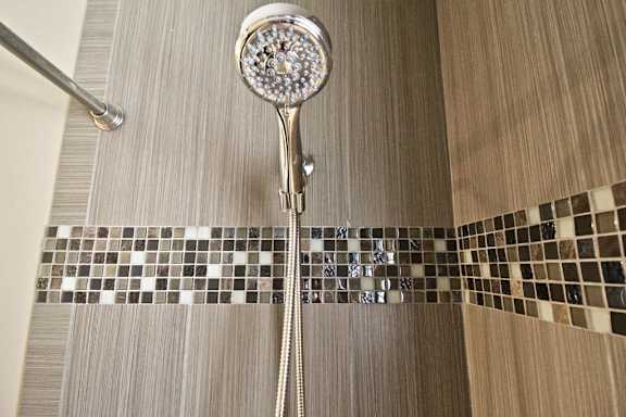 A shower head with a rain shower setting in a bathroom.