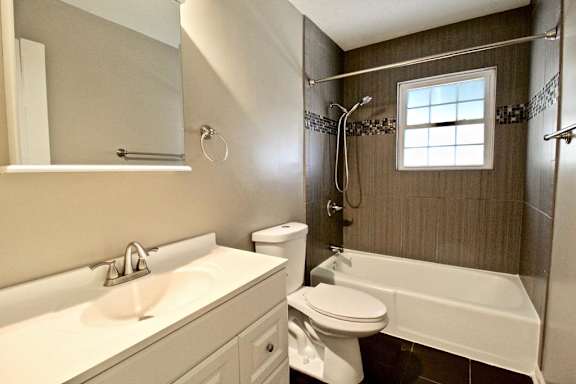 A white sink and toilet in a bathroom with a window.