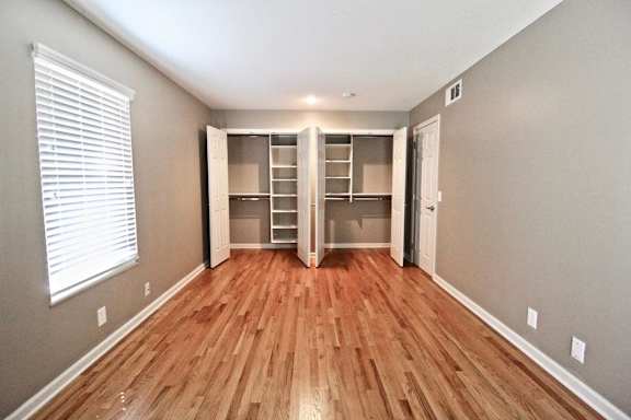 A room with wooden floors and a built-in closet.