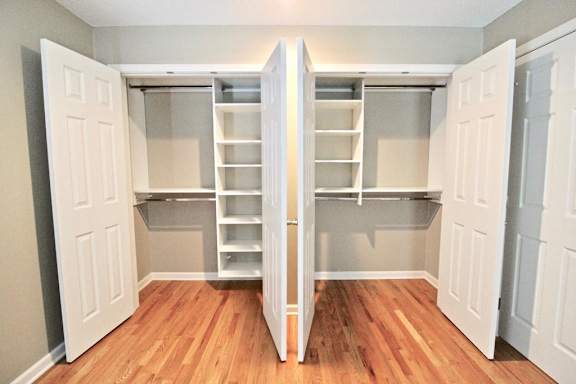 A room with a white door and a wooden floor.