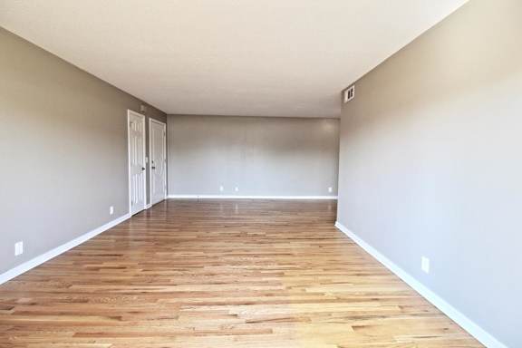 A room with wooden flooring and a white door.