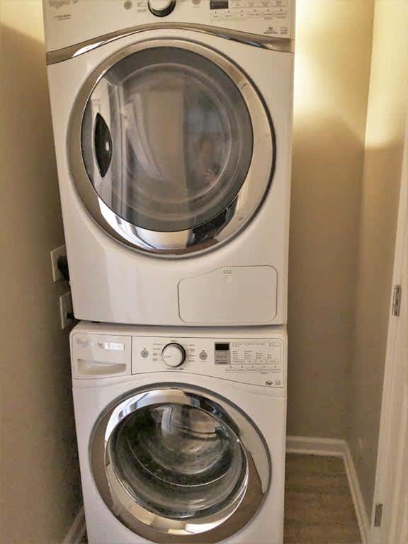 A white washing machine is stacked on top of another white washing machine.