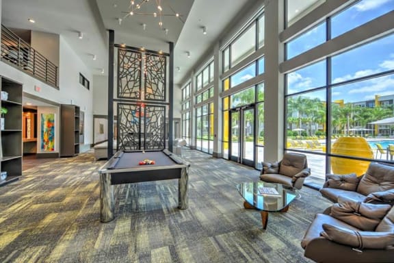 a large room with a pool table and a lot of windows  at Fusion, Jacksonville, Florida