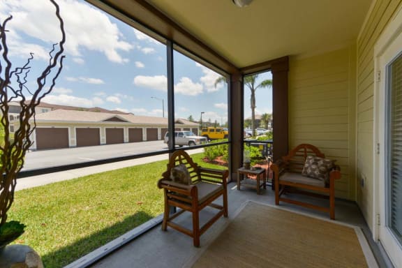 a porch with two chairs and a grassy area  at Cabana Club - Galleria Club, Jacksonville, FL
