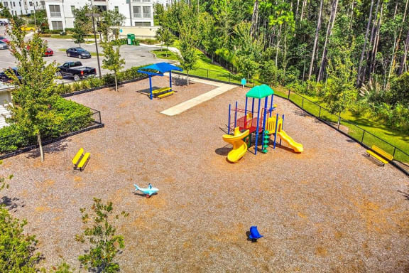a playground in a park with a parking lot in the background  at Palm Bay Club, Jacksonville, 32258