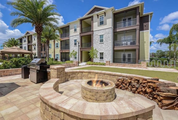 a fire pit with a grill in front of an apartment building  at Cabana Club - Galleria Club, Florida, 32256