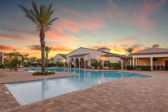 a home with a swimming pool in front of a sunset  at Hacienda Club, Jacksonville, 32256
