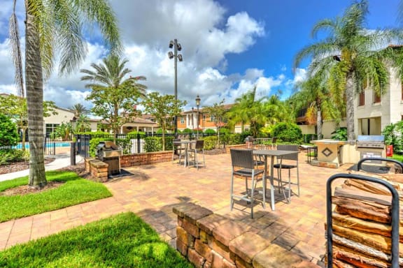 the backyard has a large patio with a fire pit and a pool in the background  at Hacienda Club, Jacksonville, Florida