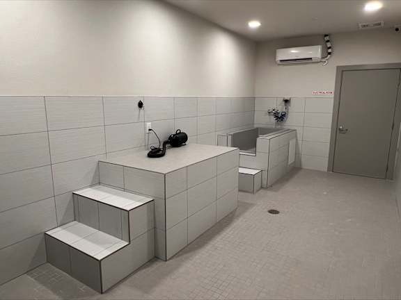 a bathroom with two urinals and a sink and a door at Pinnacle Apartments, Jacksonville, 32256