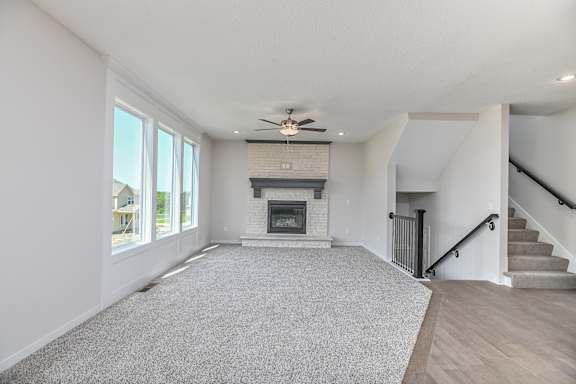 A spacious living room with a fireplace and a staircase.