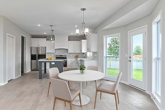 A modern kitchen with a dining table and chairs.
