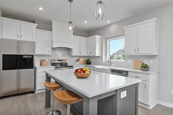 A modern kitchen with a large island and stainless steel appliances.