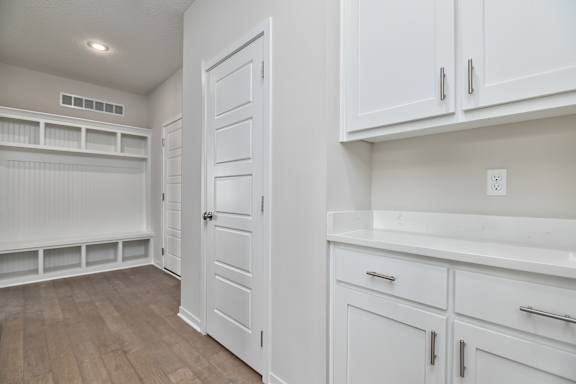 A white kitchen with a door and drawers.