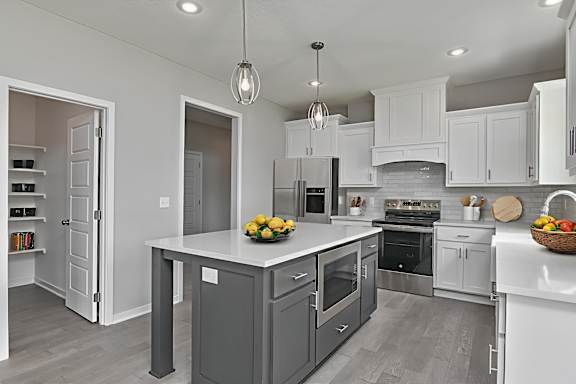 A modern kitchen with a large island and stainless steel appliances.