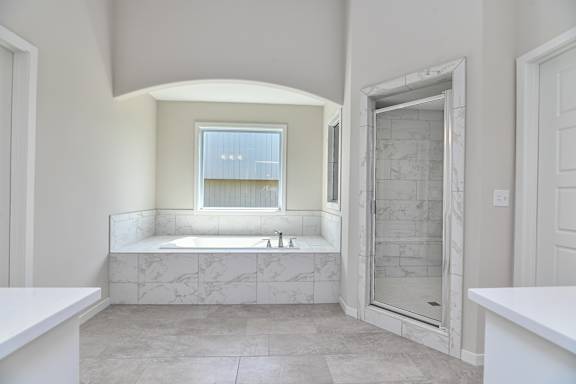 A bathroom with a marble floor and a large window.