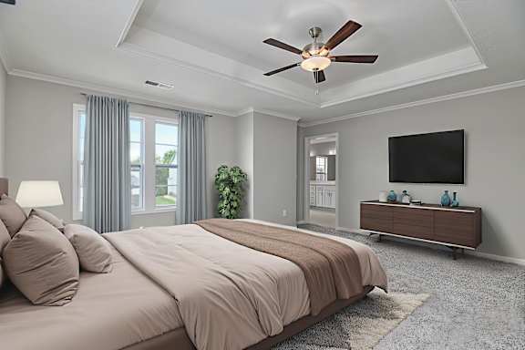 A bedroom with a large bed and a ceiling fan.