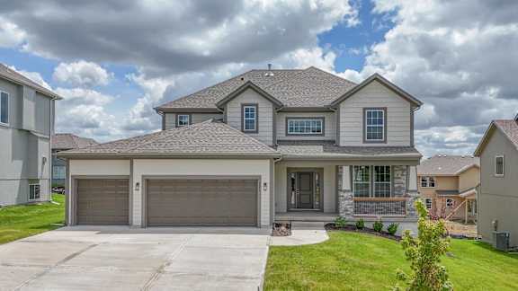 A house with a grey roof and a garage door.
