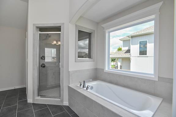 A bathroom with a tub and a window.