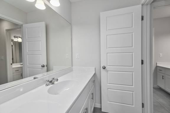 A white bathroom with a sink and mirror.
