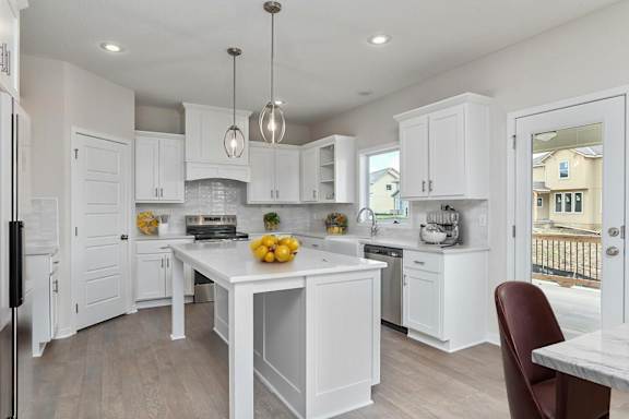 A kitchen with white cabinets and a marble table.