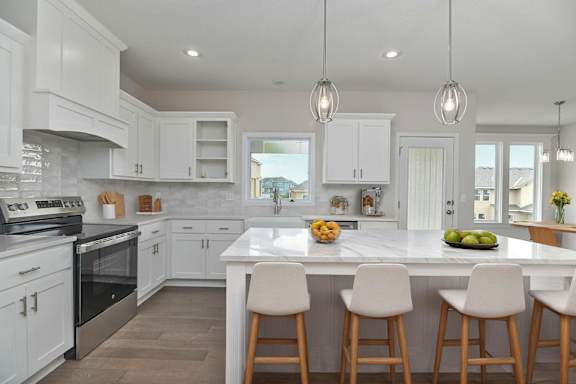 A kitchen with white cabinets and a marble countertop.