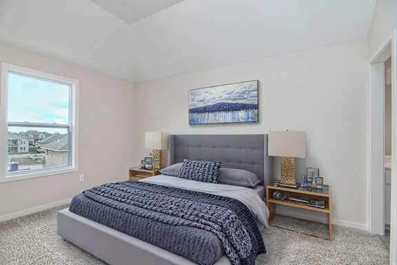 A bedroom with a large bed and a painting on the wall.