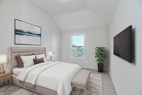 A bedroom with a large bed and a flat screen TV mounted on the wall.