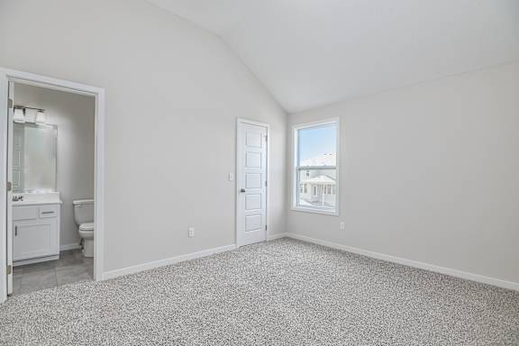 A spacious room with a carpeted floor and a view of a building outside the window.
