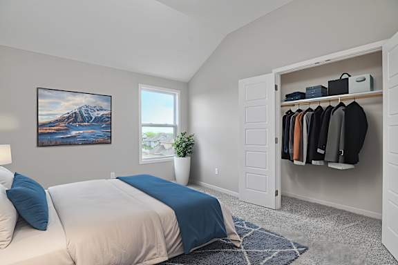 A bedroom with a large bed and a painting on the wall.