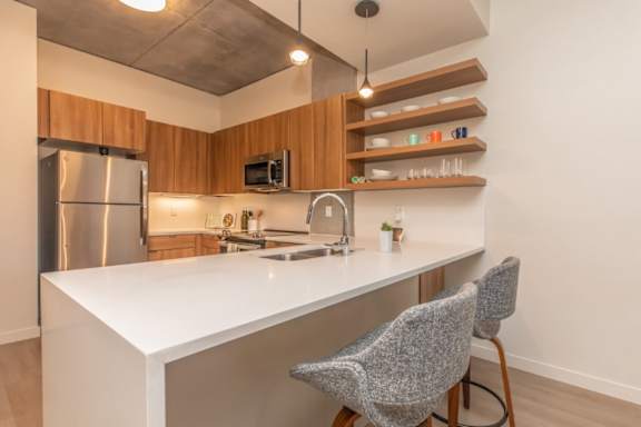 A kitchen with a white countertop and a stainless steel refrigerator.