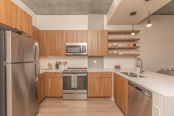 A modern kitchen with wooden cabinets and stainless steel appliances.