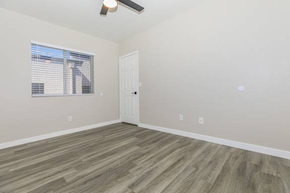 A room with a white door and a window with blinds.