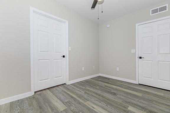 A room with a white door and a grey floor.