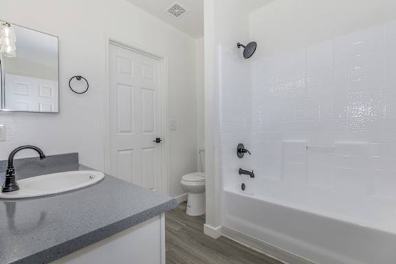 A bathroom with a sink, toilet, and shower.
