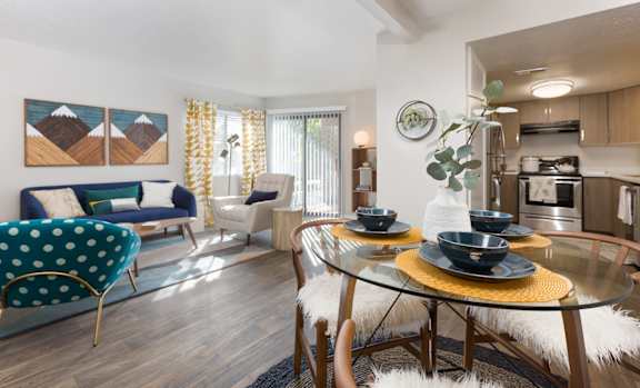 A modern living room with a glass dining table and chairs.