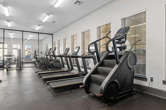 A gym with treadmills and elliptical machines.