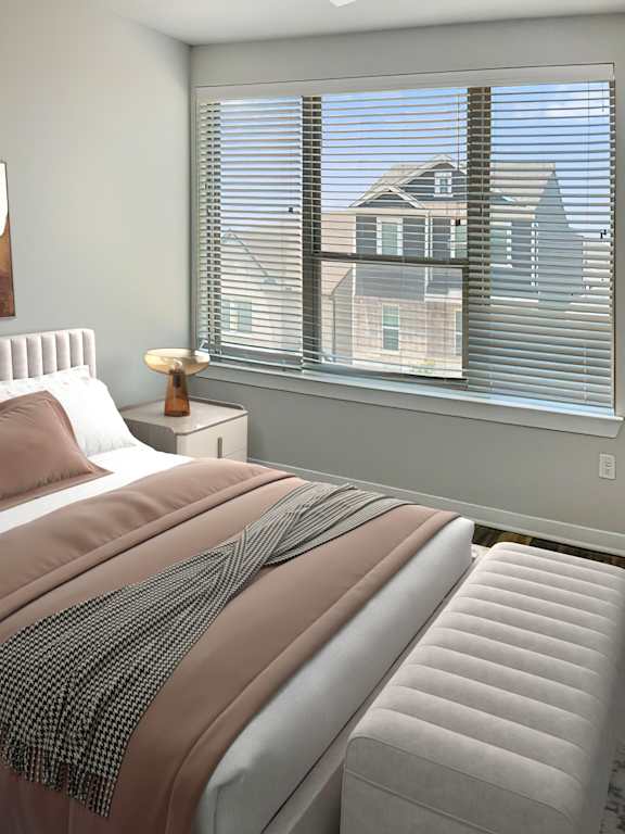A bedroom with a large bed and a window with blinds.