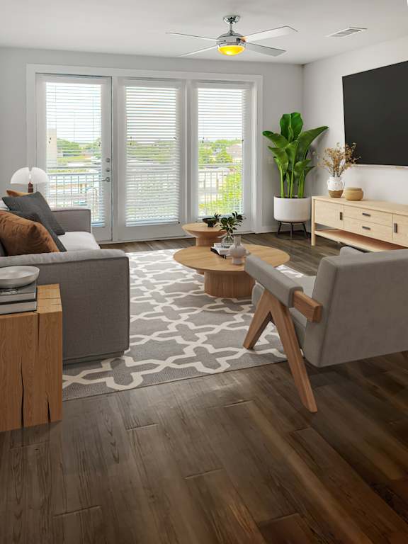A living room with a grey couch, a wooden coffee table, and a ceiling fan.