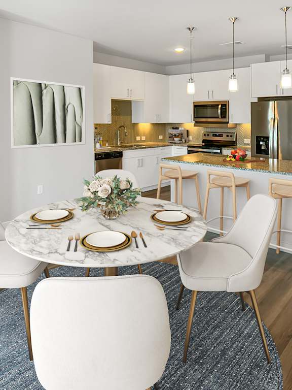 A modern dining room with a marble table and white chairs.