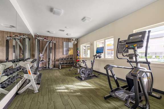 a gym with exercise equipment and mirrors on the wall