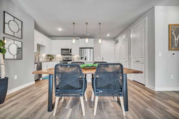 A modern dining room with a wooden table and chairs.