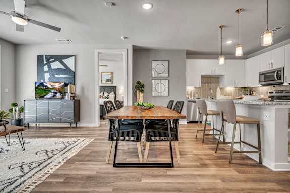 A modern dining room with a wooden table and chairs.