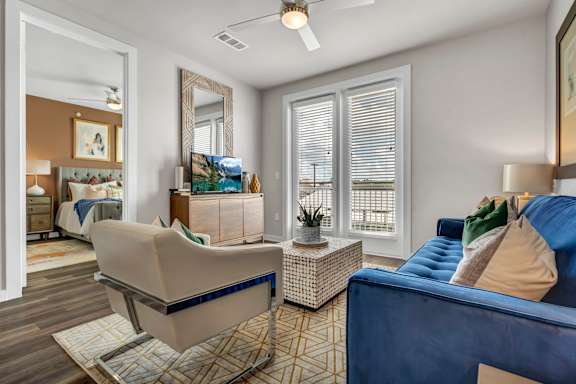 A living room with a blue couch and a beige chair.