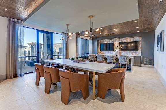 A dining room with a long table and chairs.