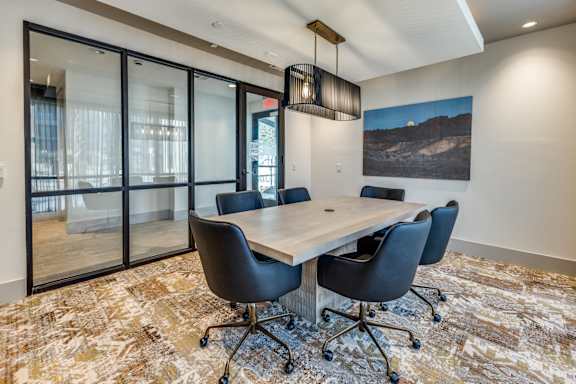 A conference room with a large table and chairs.