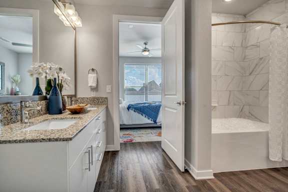 A bathroom with a white vanity and a walk-in shower.