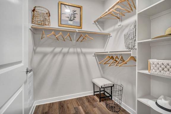 A white closet with a bench and a picture frame.