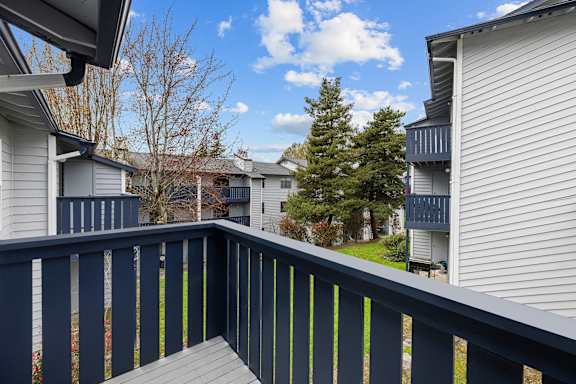 A balcony with a dark blue railing and a grey deck.