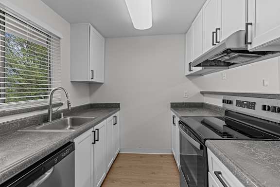 A kitchen with white cabinets and stainless steel appliances.
