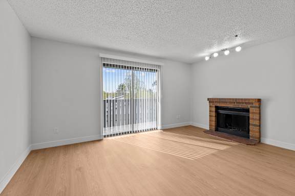 A room with a fireplace and a sliding glass door.